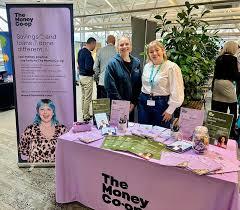 Staff promoting their money coop exhibition stand with promotional materials