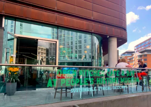 The outside entrance to the Open Kitchen cafe with seating and a balcony