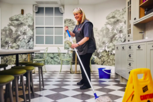 Photo of a professional cleaning a kitchen with a mop