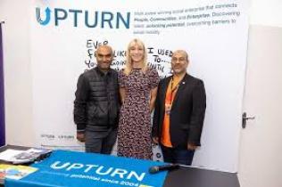 Staff standing in front of the Upturn Logo