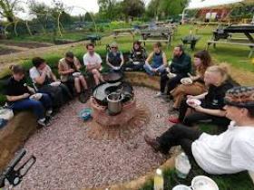 Picture of a group pf people gathered round a fire pit