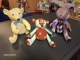 Close-up of three handmade teddy bears made with different fabrics.